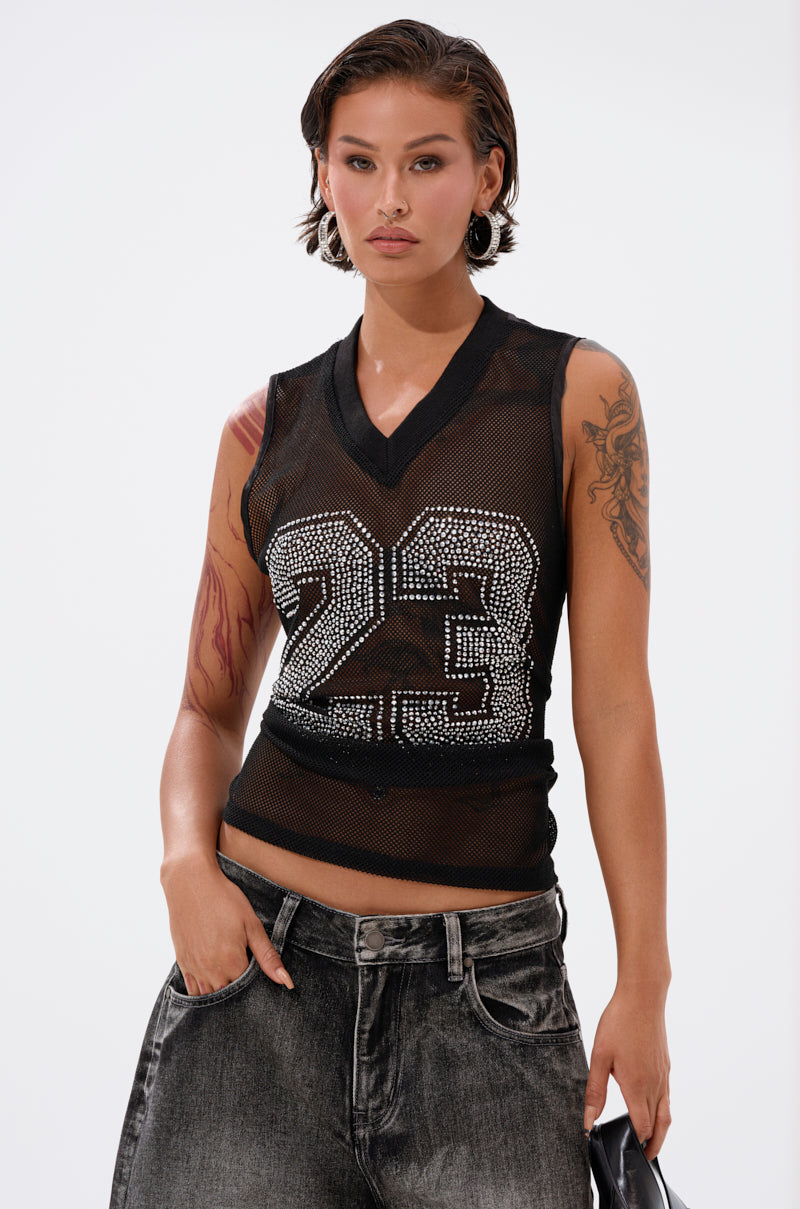 A person with short hair and visible tattoos wears the TWENTY THREE TANK, a black mesh top with rhinestone varsity  2