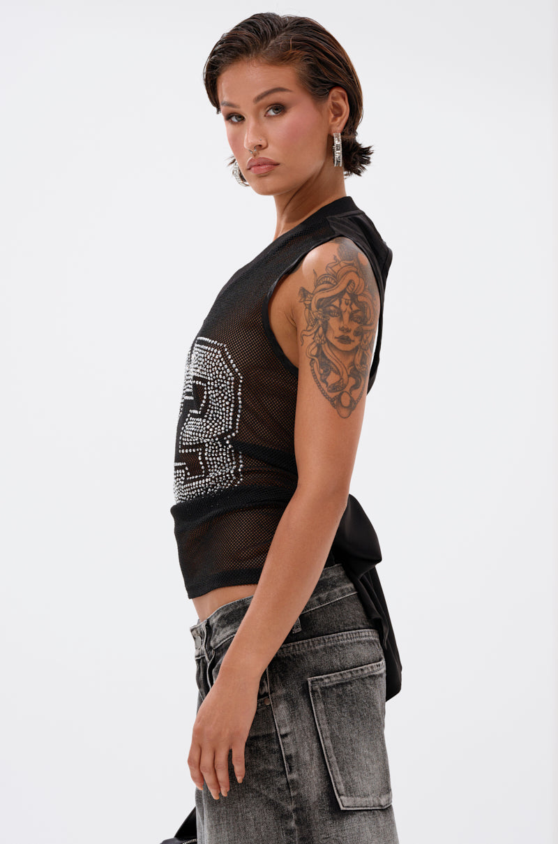A person with short brown hair, wearing the TWENTY THREE TANK varsity mesh top, hoop earrings, and faded jeans stands sideways, revealing a detailed upper arm tattoo. 3