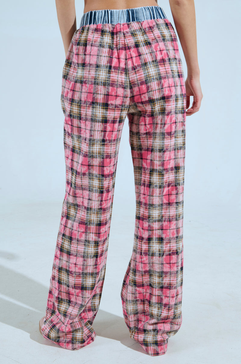 A person stands with their back to the camera wearing THE ONE PINK PLAID WIDE LEG PANT, set against a plain light background.