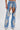 Someone wears DIVALICIOUS DENIM CHAPS IN LIGHT BLUE with large cutouts exposing beaded fringe shorts and rhinestone chain link fringe. The chaps have silver embroidery, pearl-like accents, and are styled with pointed silver shoes.