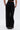 A person wearing the PEARL GIRL JOGGER, black high-rise jogger pants with pearl embellishments along the side seams, is seen from the back against a plain light background.