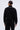 A person with a sleek bun is shown from the back against a plain light background, wearing the PEARL GIRL ZIP UP SWEATSHIRT and matching black pants with pearl embellishments along the seams.