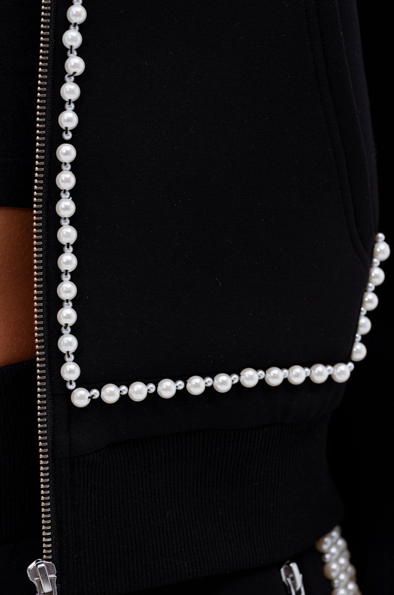 Close-up of the PEARL GIRL ZIP UP SWEATSHIRT, a black zip-up featuring elegant pearl bead trim outlining the edges.