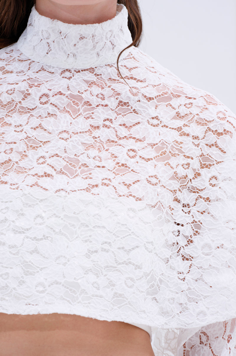A close-up of a person wearing THE PERFECT LONG SLEEVE LACE BLOUSE, featuring a high neck and sheer floral lace with an intricate pattern. Only the lower face, neck, shoulders, and upper chest are visible.