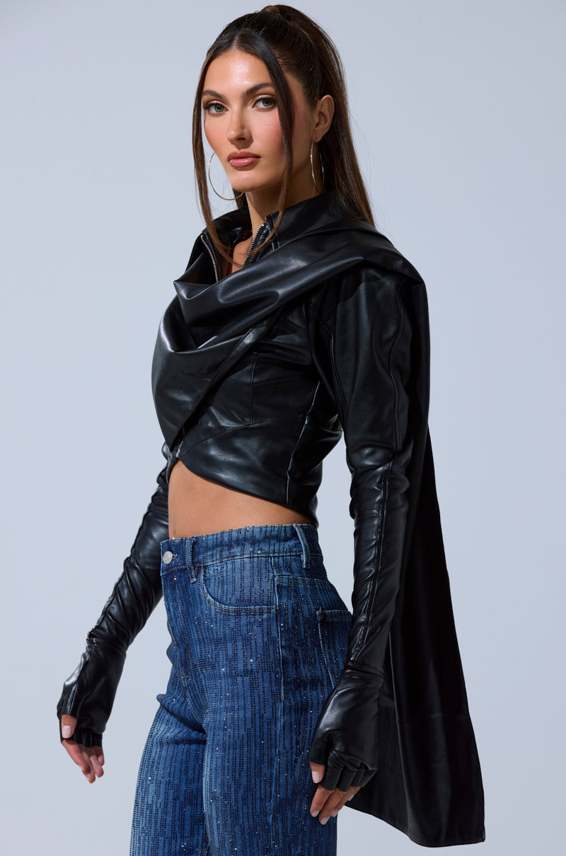 A woman in the I'M NOT LIKE THE REST TOP, featuring strappy faux leather detailing, stands confidently and exudes modern, edgy style.