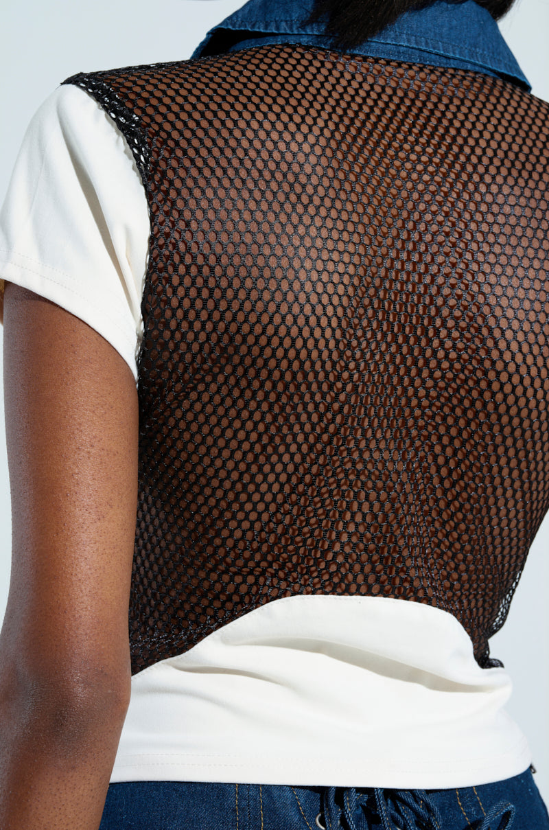 A person is seen from the back wearing the EDGY DIVA SHORT SLEEVE NETTED TSHIRT, which features a black mesh design over a white short-sleeved base. The chic, stylized appearance highlights the intricate mesh pattern as their lower back and shoulders are visible while they face away from the camera.