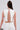 Wearing the SPARKLE QUEEN BLOUSE and matching skirt, this person with long brown hair holds a small round handbag and has a medical glucose monitor on their upper arm.