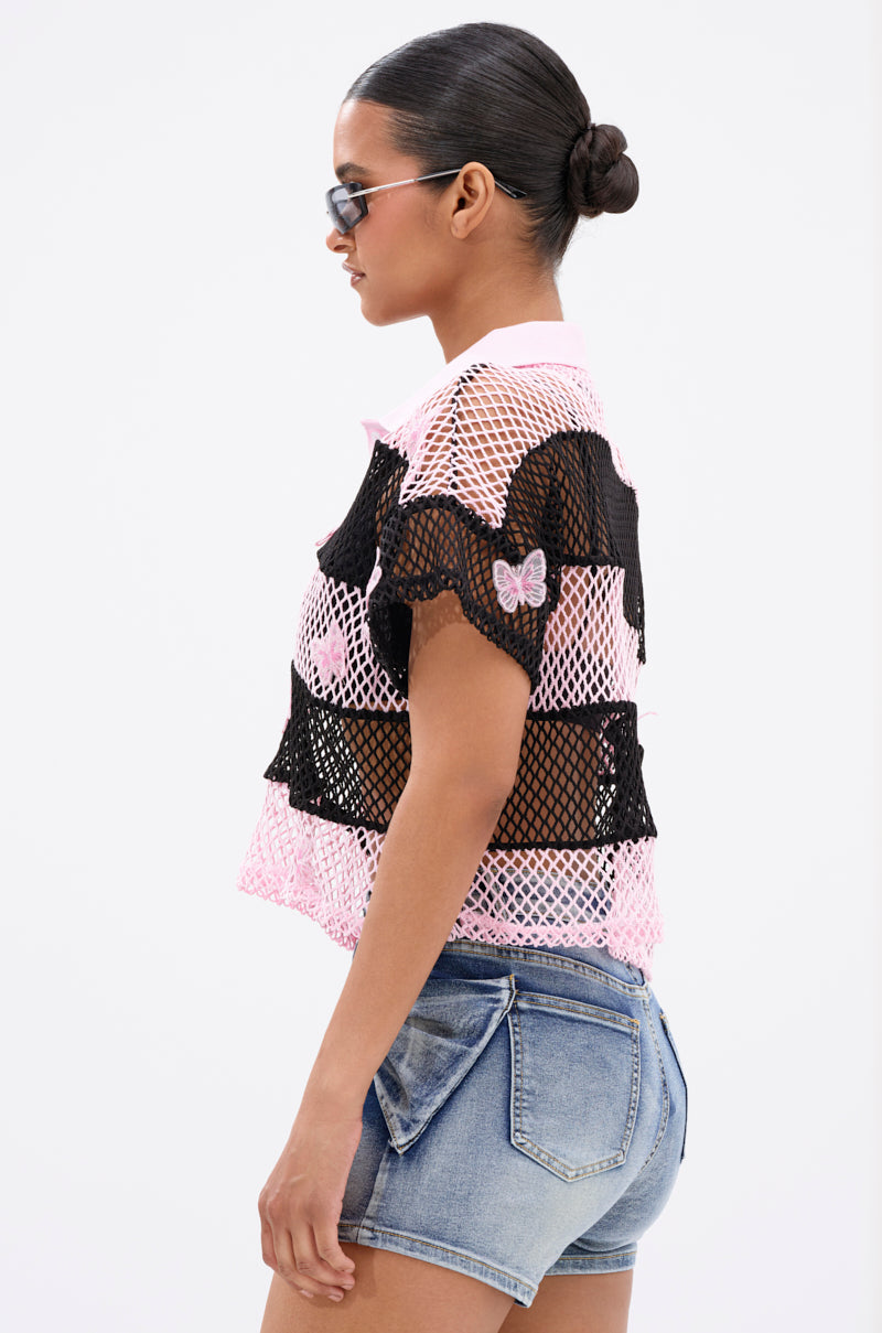 A woman with slicked-back hair in a bun and sunglasses is shown in profile against a plain white background, wearing the FLY WITH ME STRIPE OVERSIZED TEE and denim shorts.
