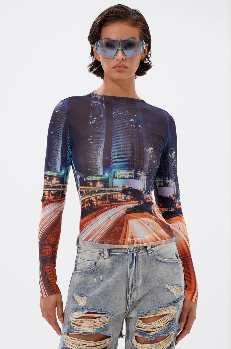 A person in blue sunglasses, distressed light-wash jeans, and the CITY LOVER MESH LONG SLEEVE poses against a white background for an urban-chic look. 2