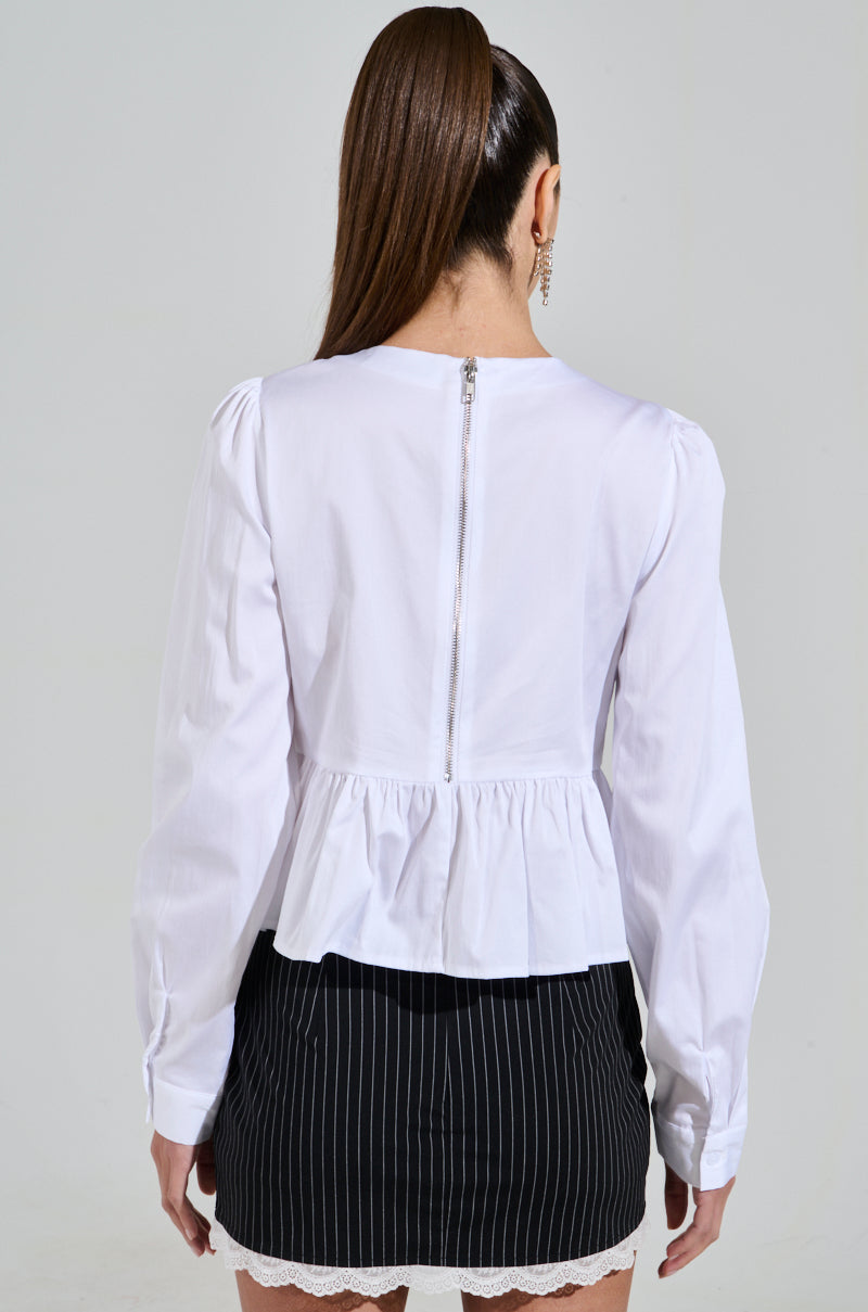 A woman, back to the camera, wears a chic Diamond Bow Button Up and a black pinstripe skirt. Her ponytail and earrings capture the essence of Coquette Fashion.
