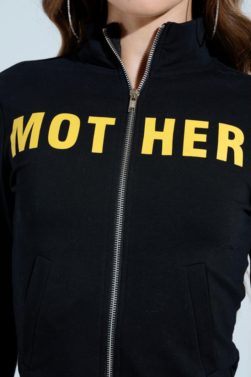 Someone is wearing a MOTHER F*UCKER ZIP UP SWEATSHIRT by the AKIRA Label, featuring a bold graphic print with "MOTHER" in large yellow letters across the chest, partially obscured by the zipper.