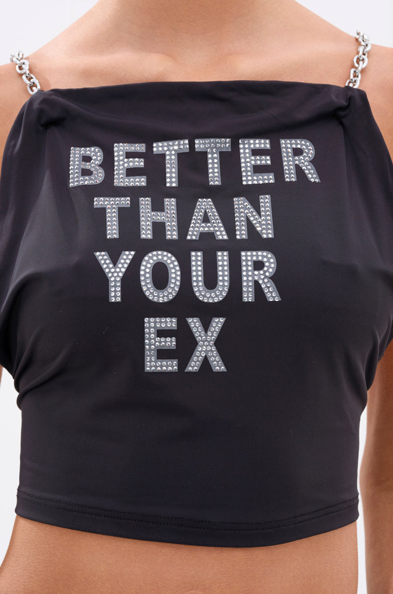 A person wearing the BETTER THAN YOUR EX RHINESTONE TOP, a black crop top featuring chain link straps and sparkling rhinestone-studded "BETTER THAN YOUR EX" text.