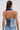 A woman with a ponytail and hoop earrings is seen from the back, wearing the ALWAYS RIGHT DENIM ABSTRACT BLOUSE styled with denim jeans.
