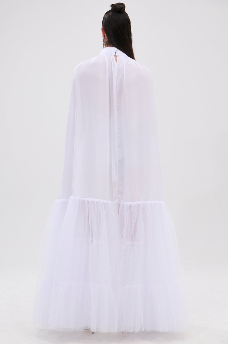 A person with dark hair in a top knot wears the DONT WASTE MY TIME BLOUSE, a long, flowing white blouse with sheer mesh and voluminous gathered sleeves, standing against a plain light-colored background. 6