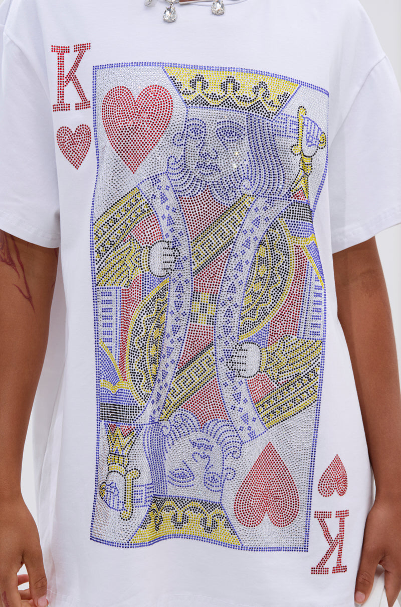 A person wears the KING OF HEARTS OVERSIZED TEE IN WHITE, showing only their torso and featuring a bold, colorful playing card graphic on the front.