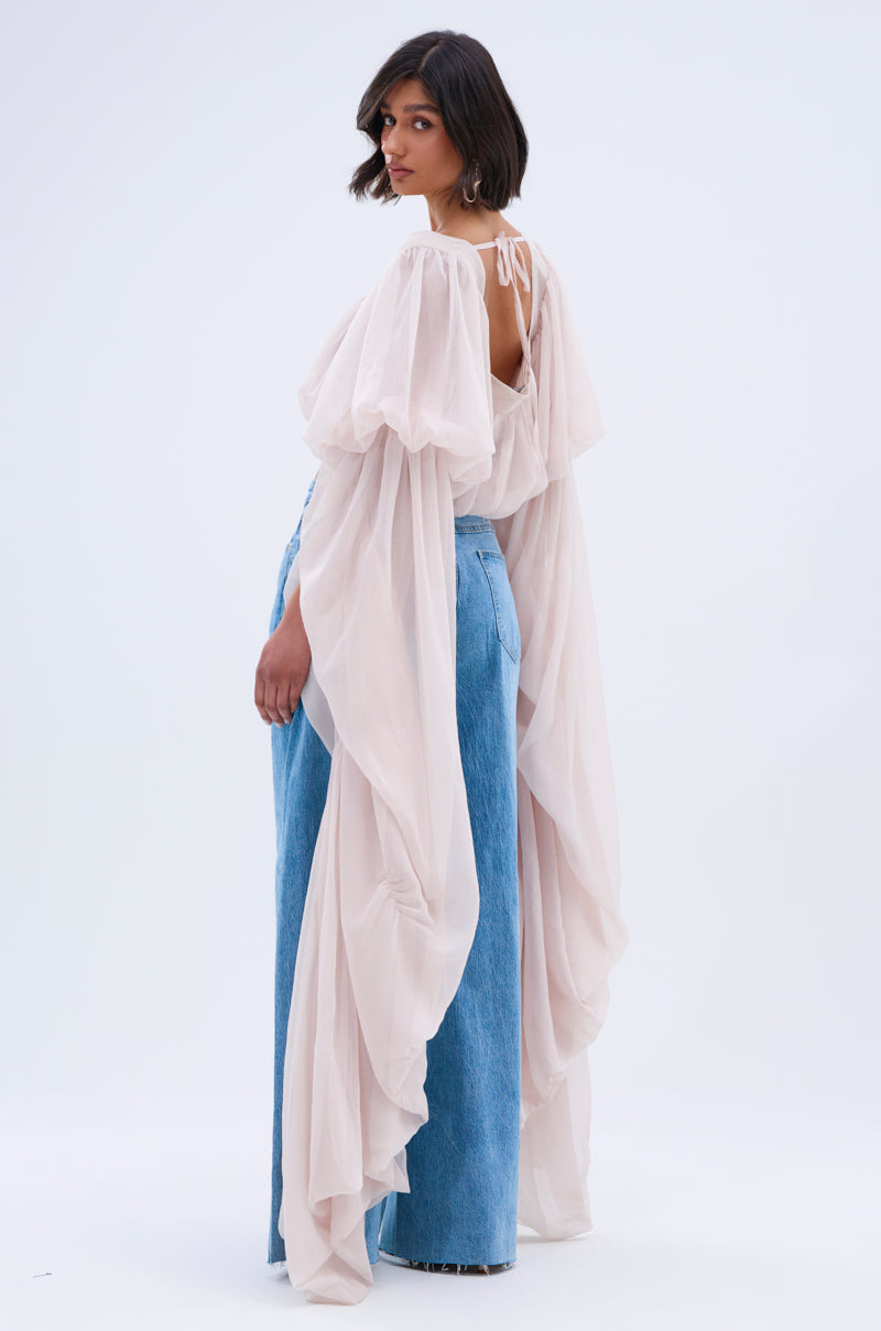 A woman poses in a sheer, flowing SLOUCHY SQUARE NECK LONG SLEEVE BLOUSE TOP with billowy sleeves over light blue wide-leg jeans against a plain light background.