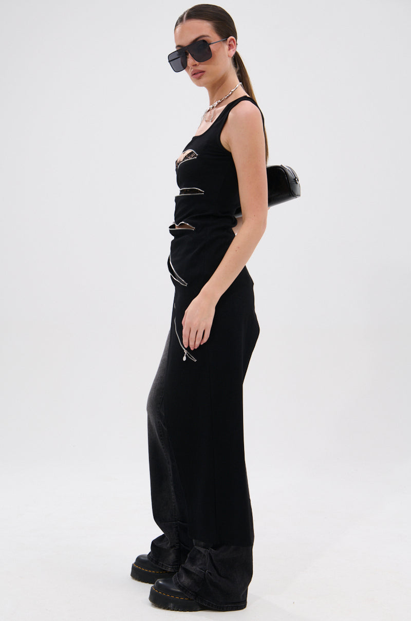 A woman poses in the TOO GOOD FOR YOU BLOUSE WITH ZIPPERS, styled with chunky black boots, sunglasses, a chain necklace, and a small black shoulder bag against a plain white background.