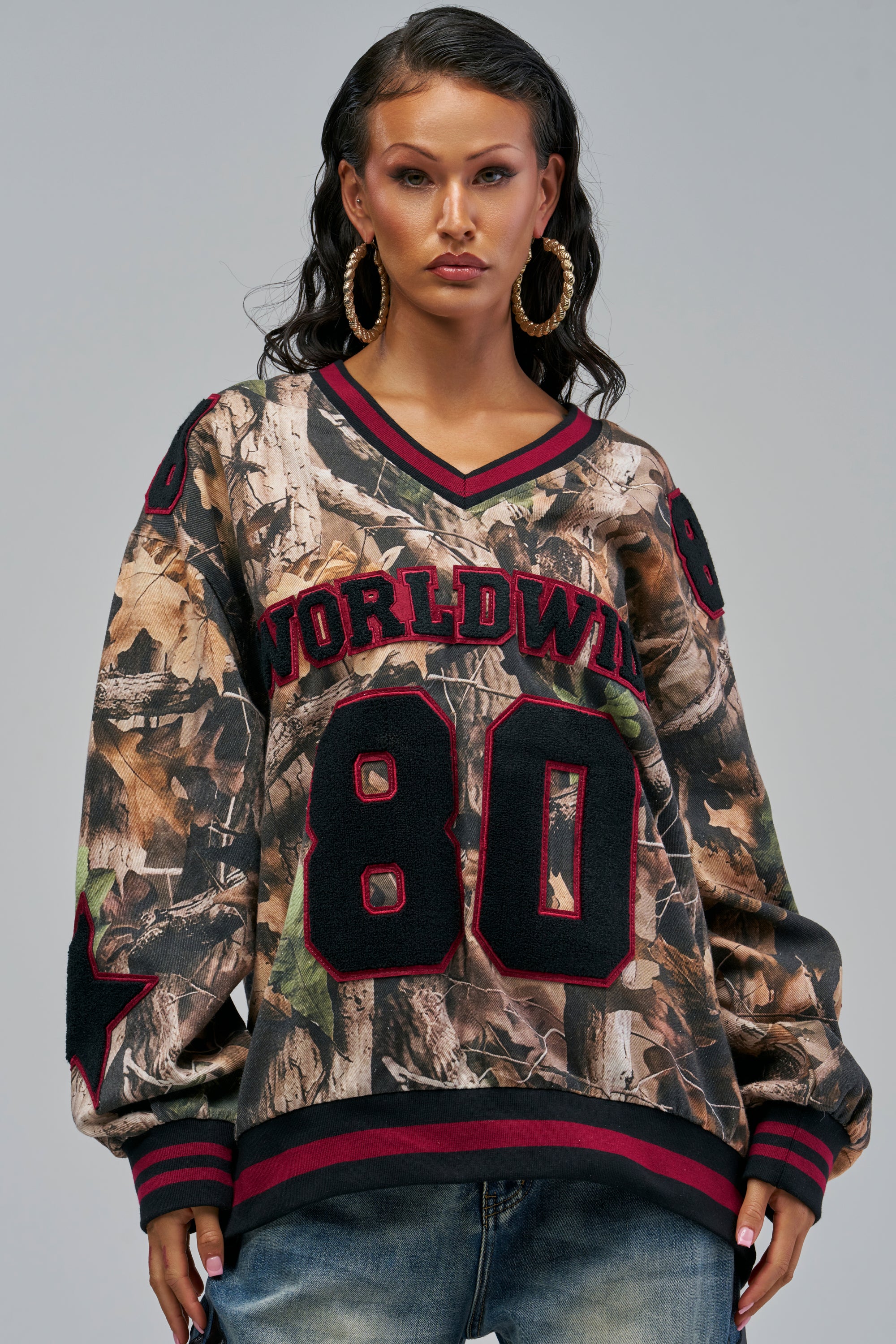 IN MY OWN WORLD DENIM SWEATSHIRT IN CAMO featuring an oversized V-neck fit, a camo print, and “WORLDWIDE” with the number “80” in large black and red letters on the front.