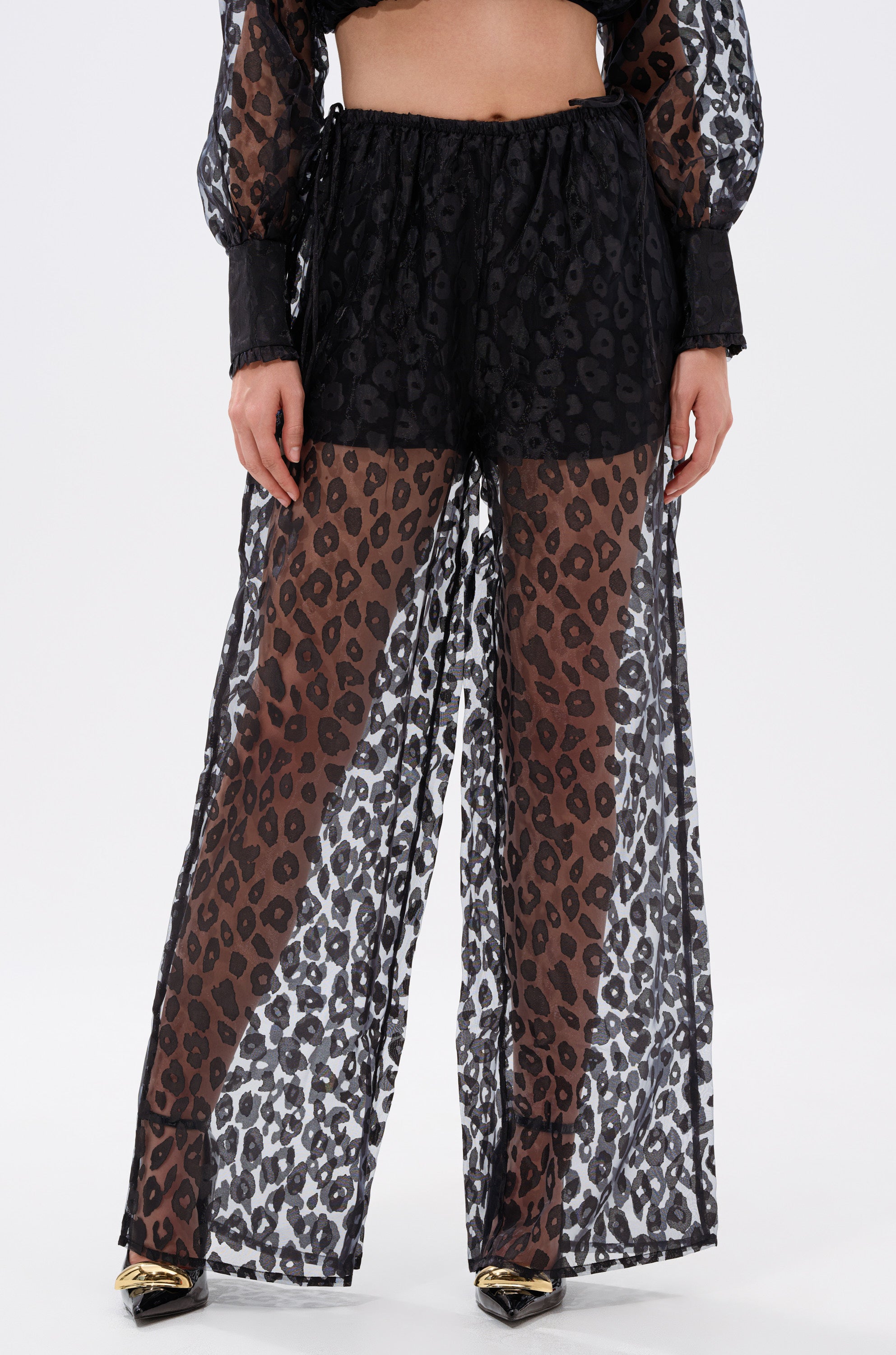 Someone stylishly wears the CHEETAH SISTA PALAZZO PANT in black and white cheetah print, pairing bold style with effortless comfort.