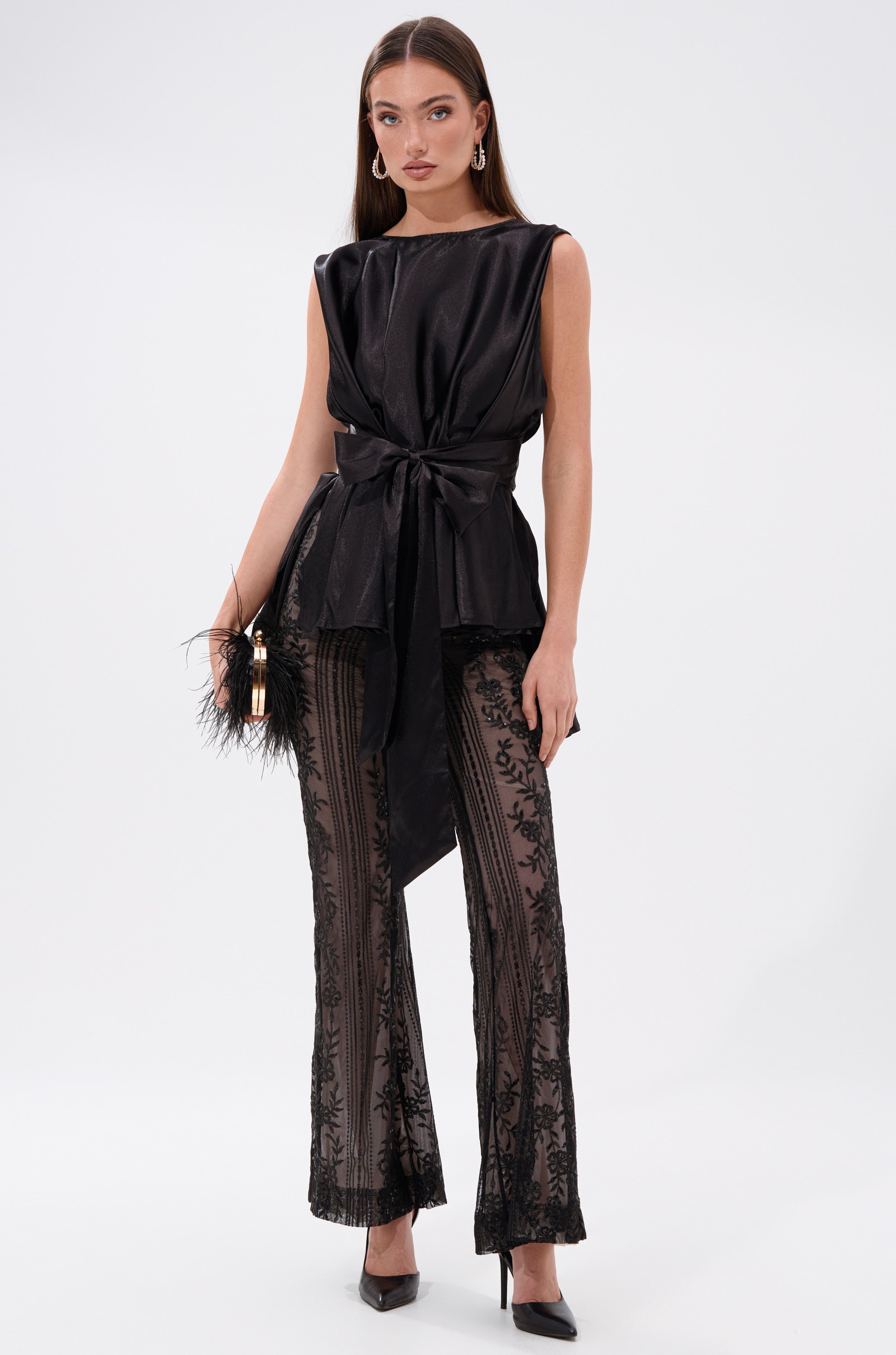 A woman in a sheer black mesh dress elegantly styled with the DEZI LACE TROUSER. 4