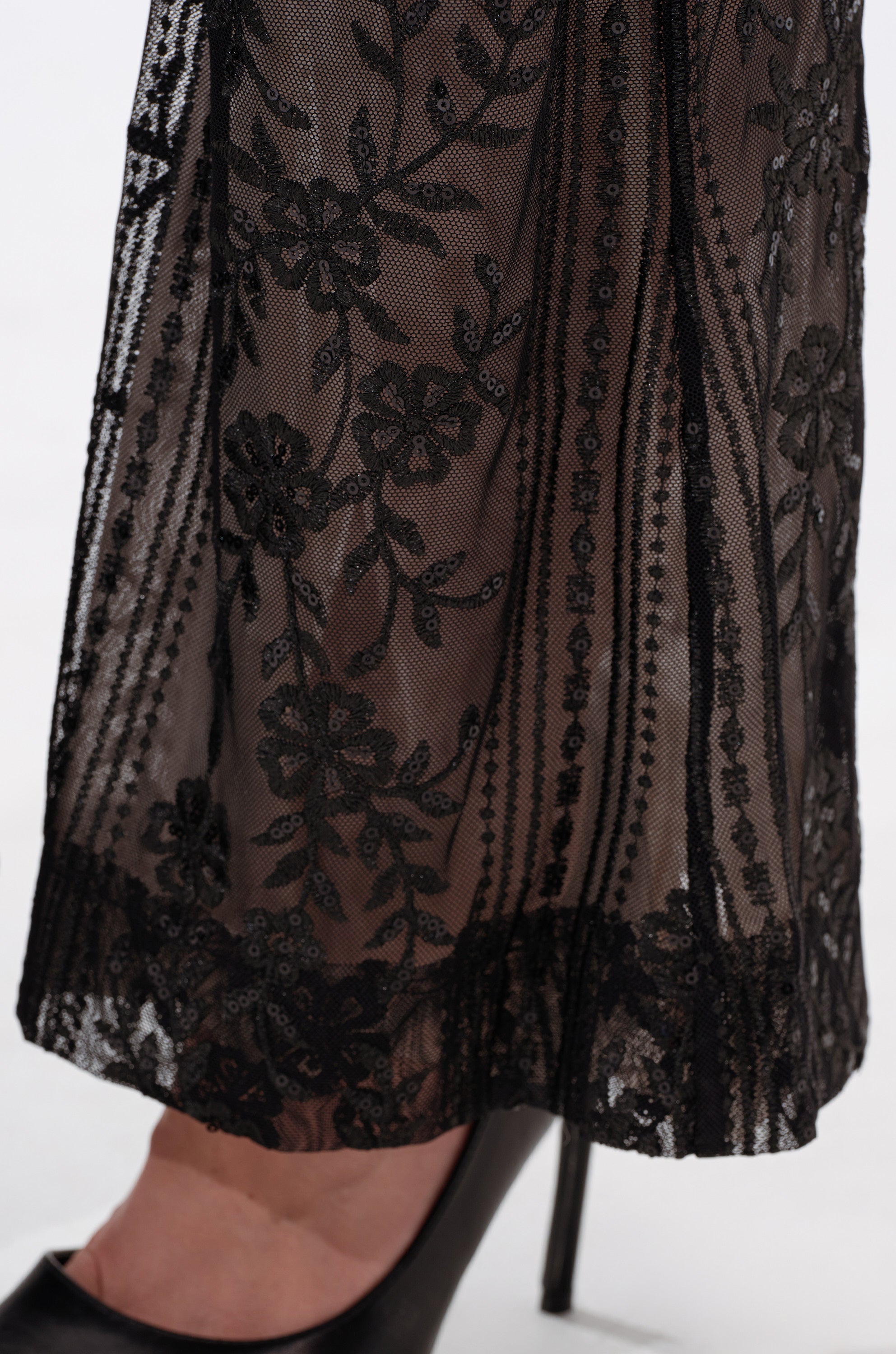 A close-up of the DEZI LACE TROUSER showcasing black lace fabric and sheer black mesh details. 6