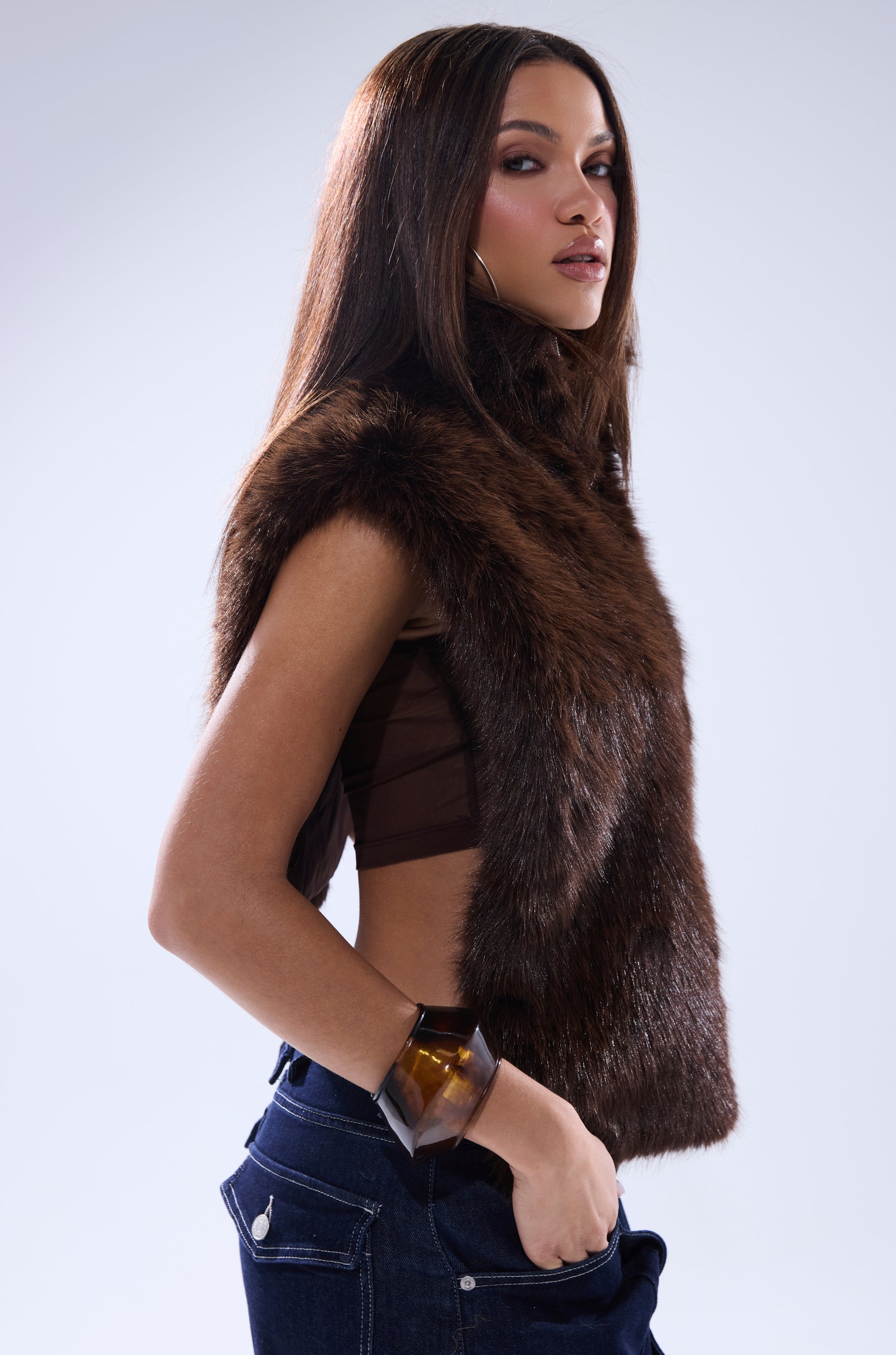 A woman with straight brown hair models the SURE THANG FUR TURTLENECK PULLOVER with dark jeans and a chunky bracelet, posing confidently over her shoulder against a light background. 4
