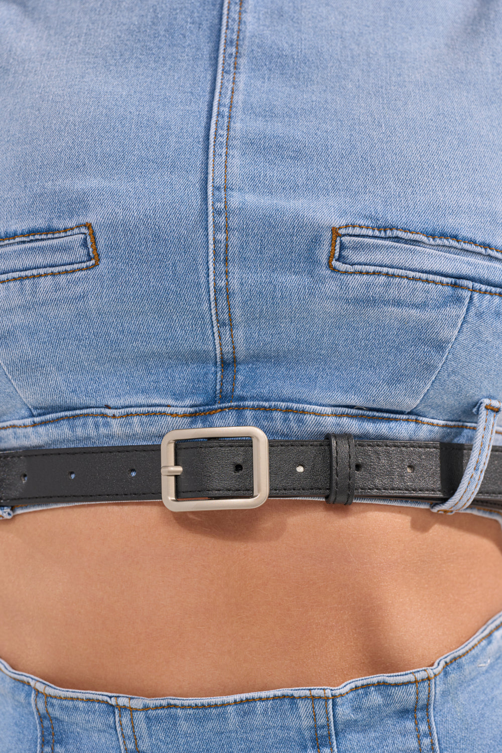 Close-up of a person wearing the JENNY DENIM BLOUSE with a black leather belt and silver buckle, showcasing streetwear style around the midsection. 10