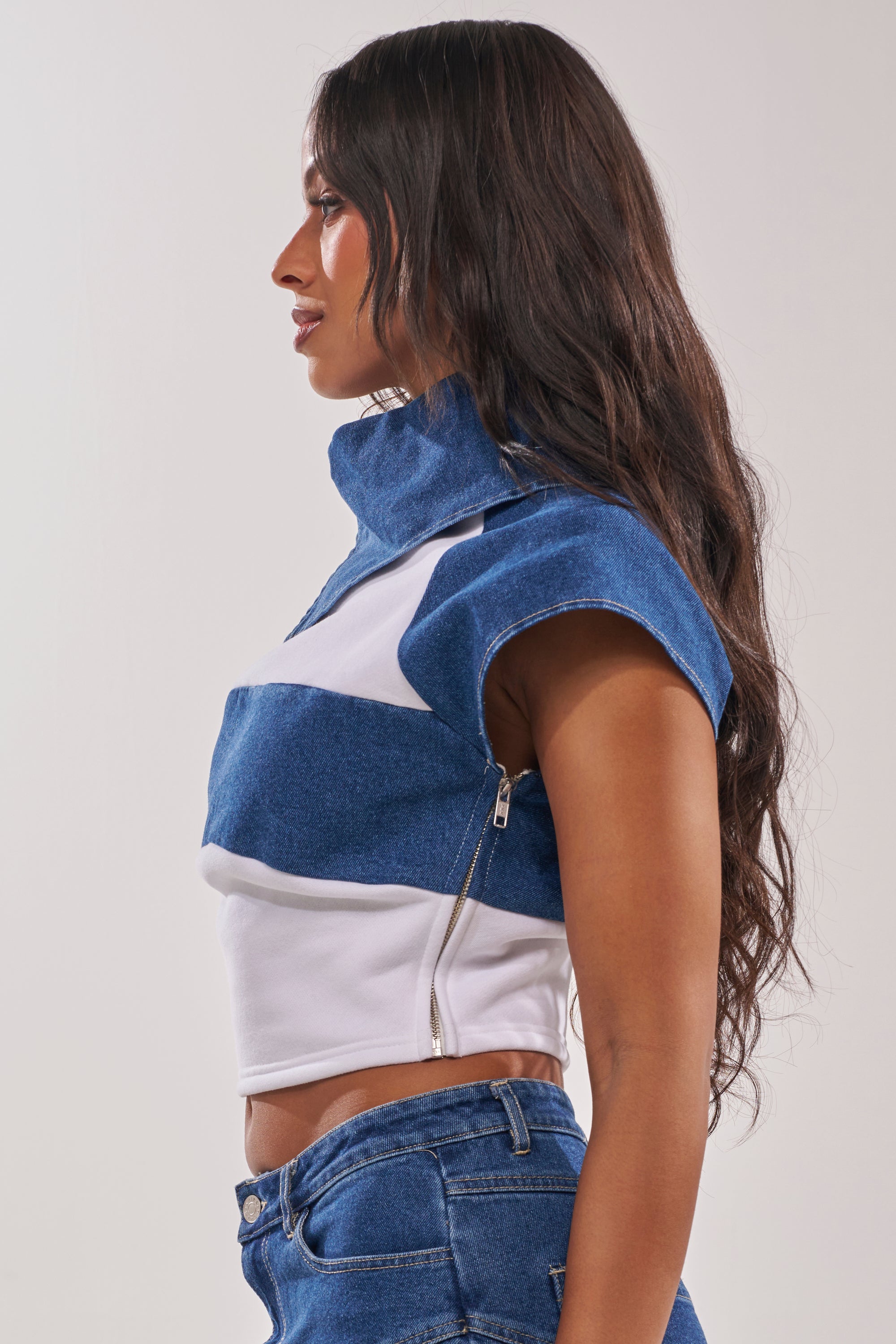 A woman with long, wavy dark hair is shown in profile wearing the THIS IS EVERYTHING YOU SEE DENIM BLOUSE and blue jeans against a plain light background. 3