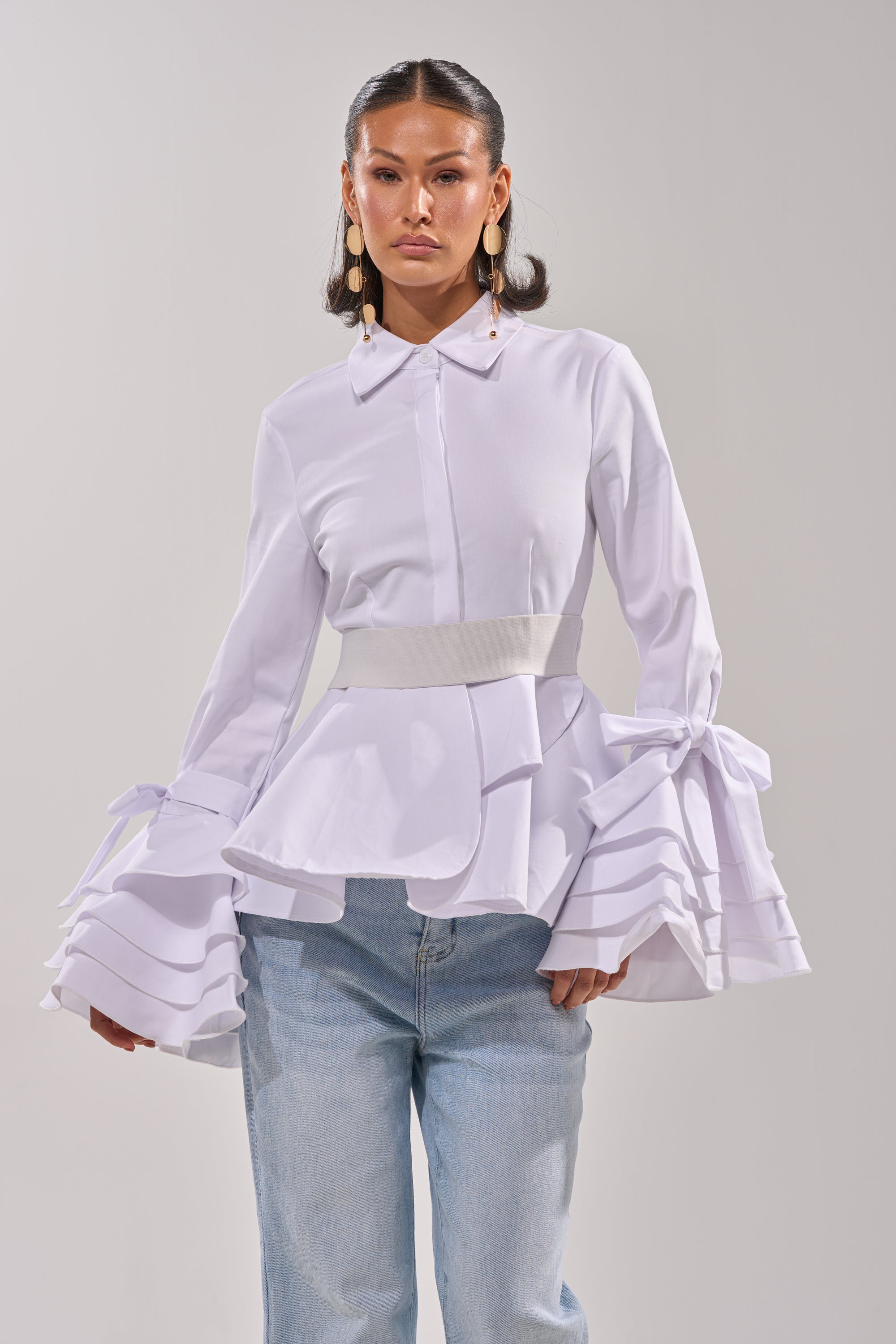 A woman wearing the ELEGANT PEPLUM BUTTON DOWN BLOUSE. 0