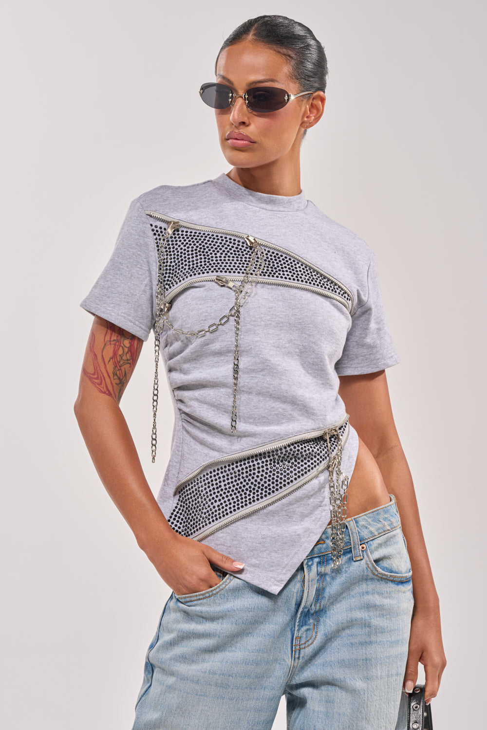 A person wears the DONT MESS OVERSIZED SWEATSHIRT, sunglasses, and light blue jeans, standing with one hand in their pocket against a plain background. 0