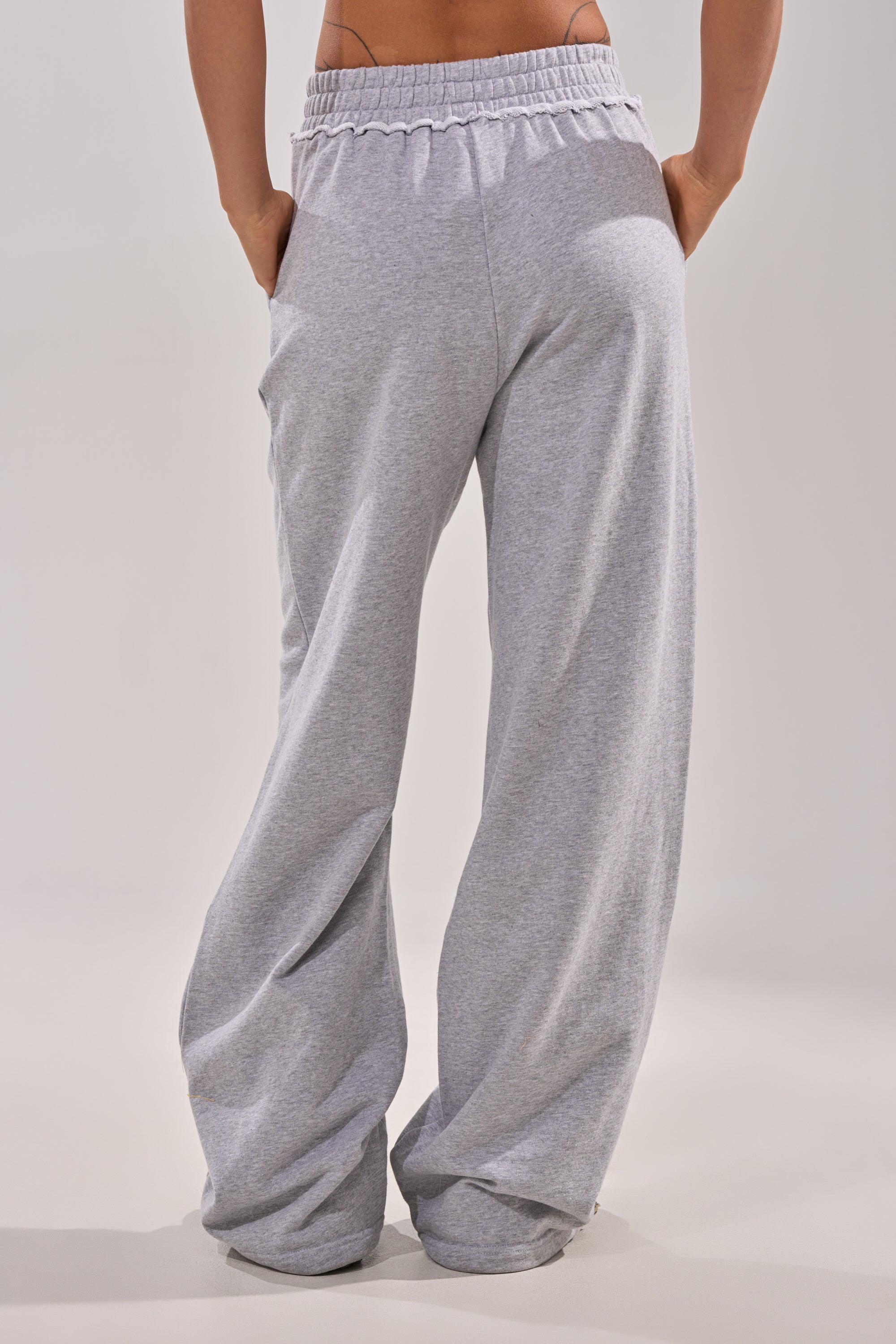 A person wearing the CROSSED OUT DISTRESSED WIDE LEG JOGGER in grey. 4