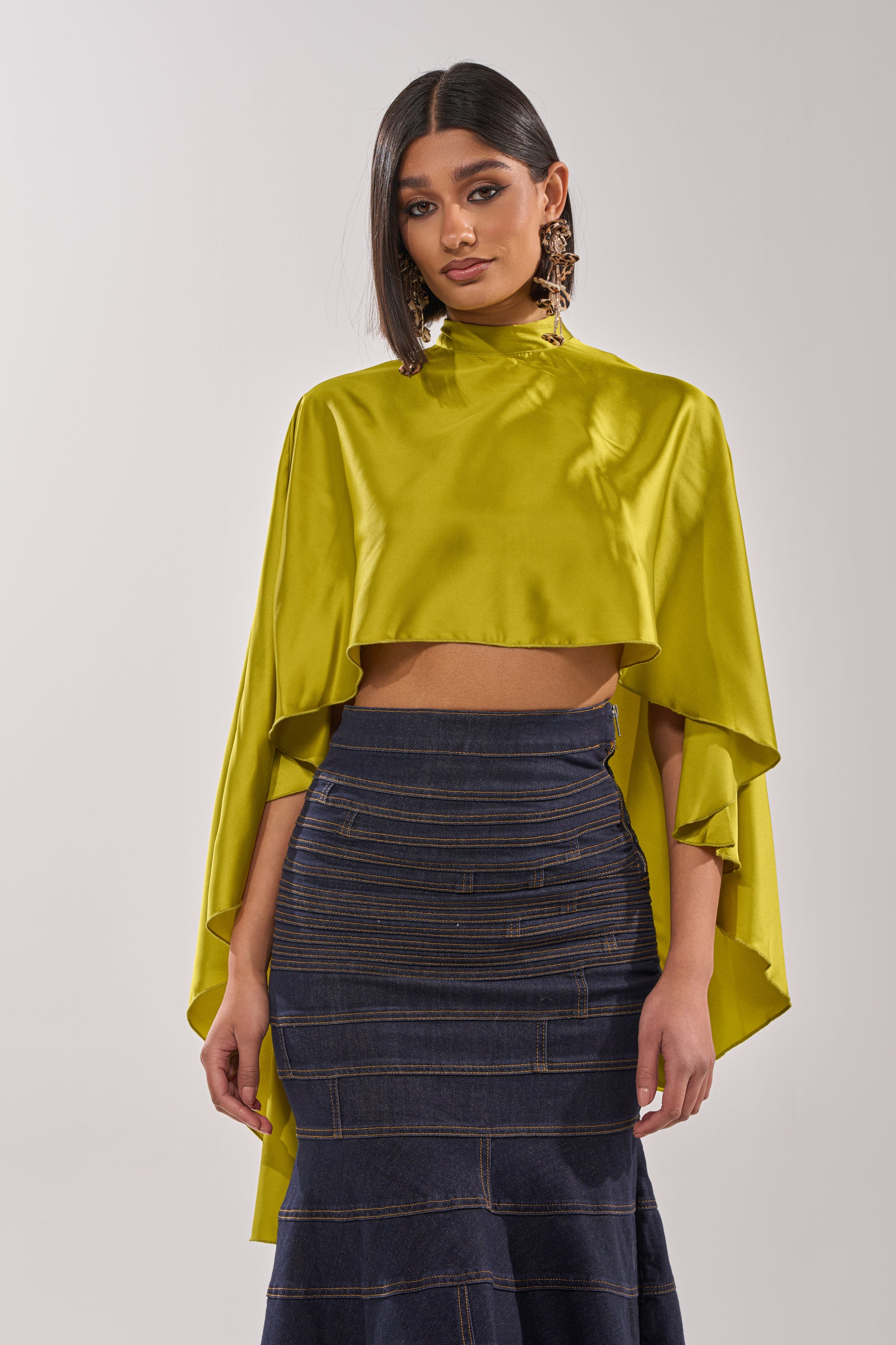 A woman in the BABY MAKE A MOVE BLOUSE IN CHARTREUSE paired with a skirt. 5