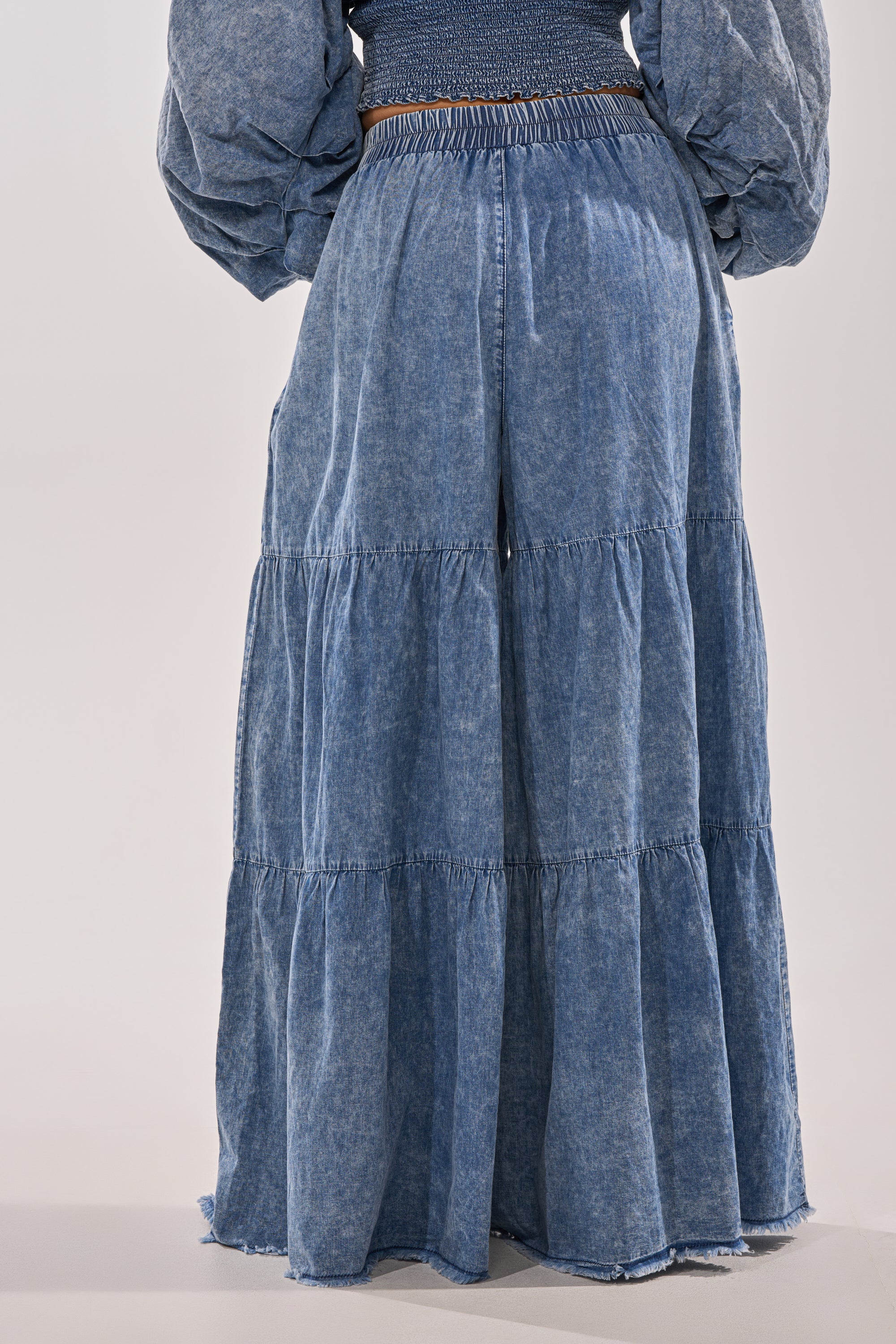 A person in DENIM FOR DAYS PALAZZO PANT and a matching long-sleeve top exudes effortless bohemian style, standing against a plain light background.