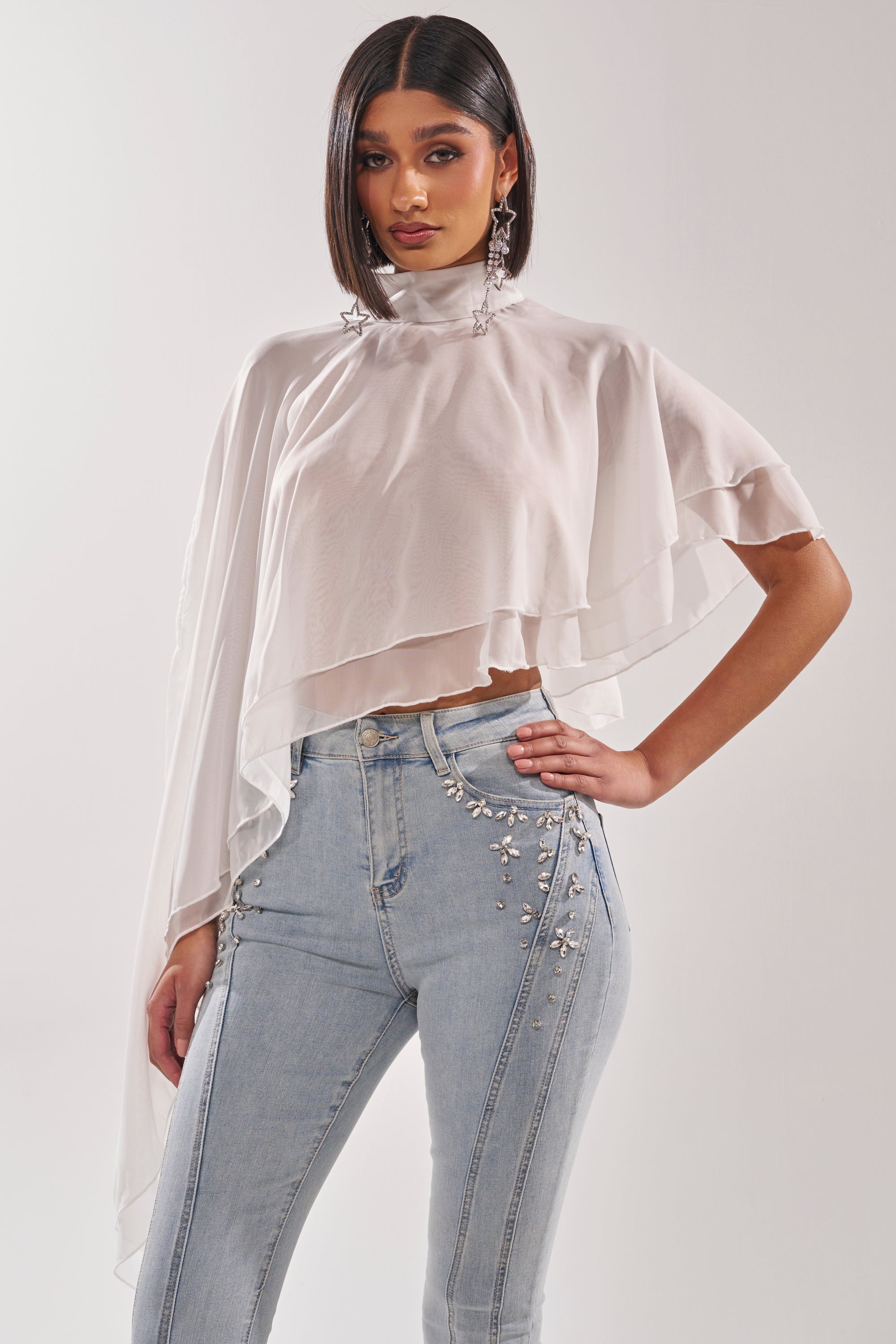 A woman posing for a picture in the FOLLOW ME DRAPEY BLOUSE, featuring white chiffon fabric, a mock neckline, and a flowy silhouette. 0