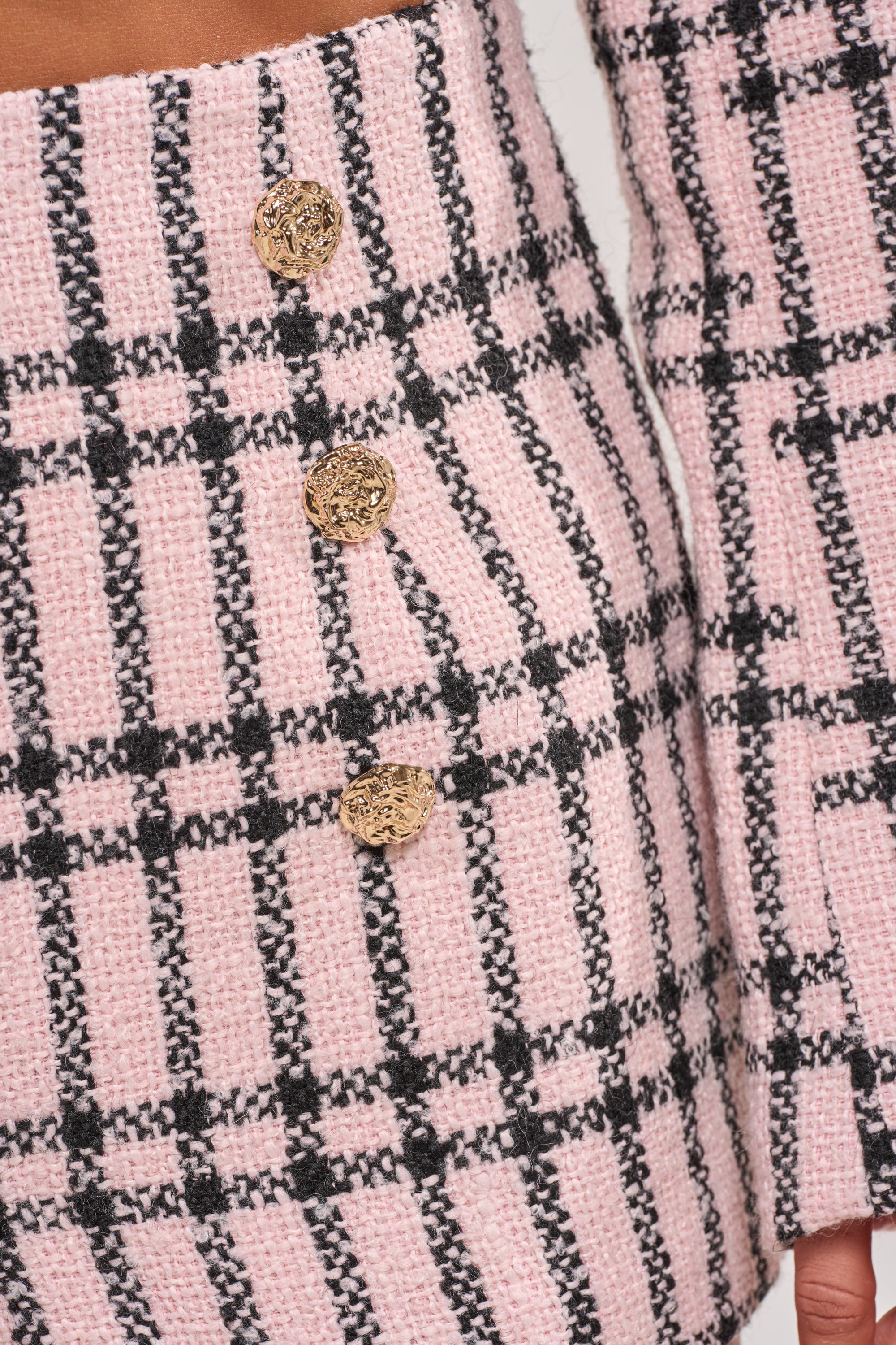Close-up of LOOK AT ME BABY TWEED SHORT in pink and black checkered tweed with three gold buttons, featuring matching high-rise mini shorts—ideal for a chic brunch outfit. 5