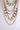 The OMG SLAY Layered Chain Necklace in Gold, featuring chunky chain links, is elegantly displayed against a neutral background. The necklace catches the light beautifully, highlighting its shiny surface and intricate design.