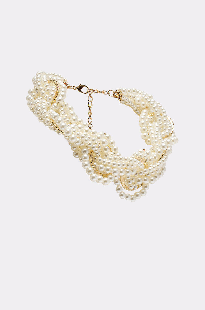 The SHARON NECKLACE is a multi-strand, twisted necklace featuring faux pearls, a gold chain, and clasp. It is displayed on a plain light gray background. 3