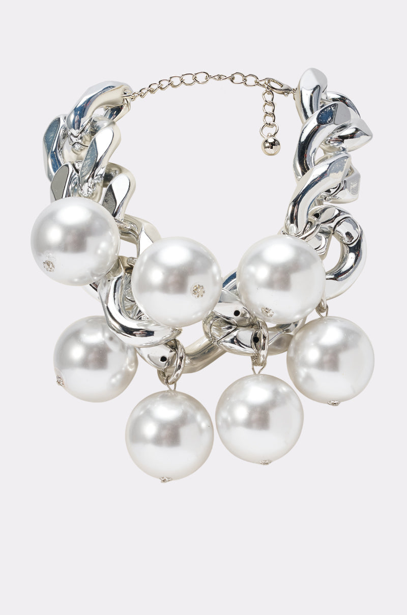 The PEARLY NECKLACE features a chunky silver chain with large glossy white pearls and sparkling rhinestones, showcasing bold avant garde style and an adjustable clasp.