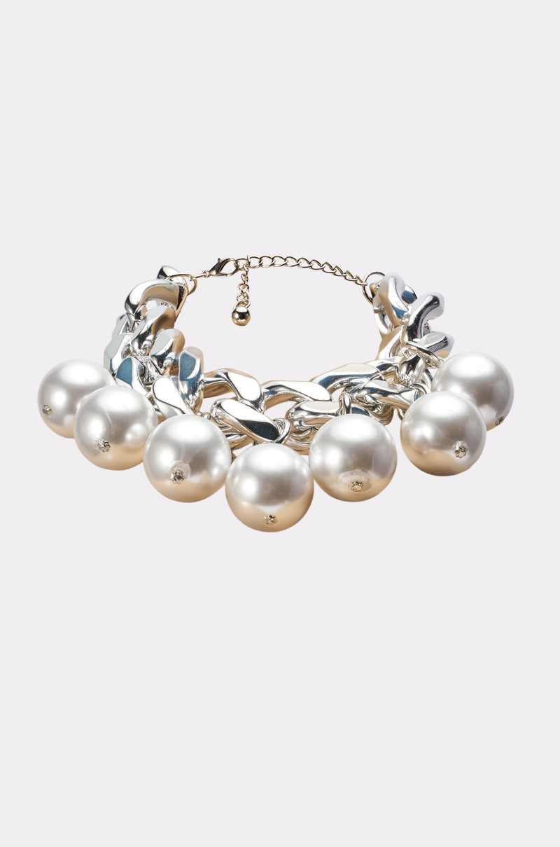 Introducing the PEARLY NECKLACE—a chic statement piece showcasing a chunky silver chain embellished with large white pearls, each evenly spaced and highlighted by a delicate crystal accent. Finished with an adjustable clasp, this pearl choker ensures a perfect fit.