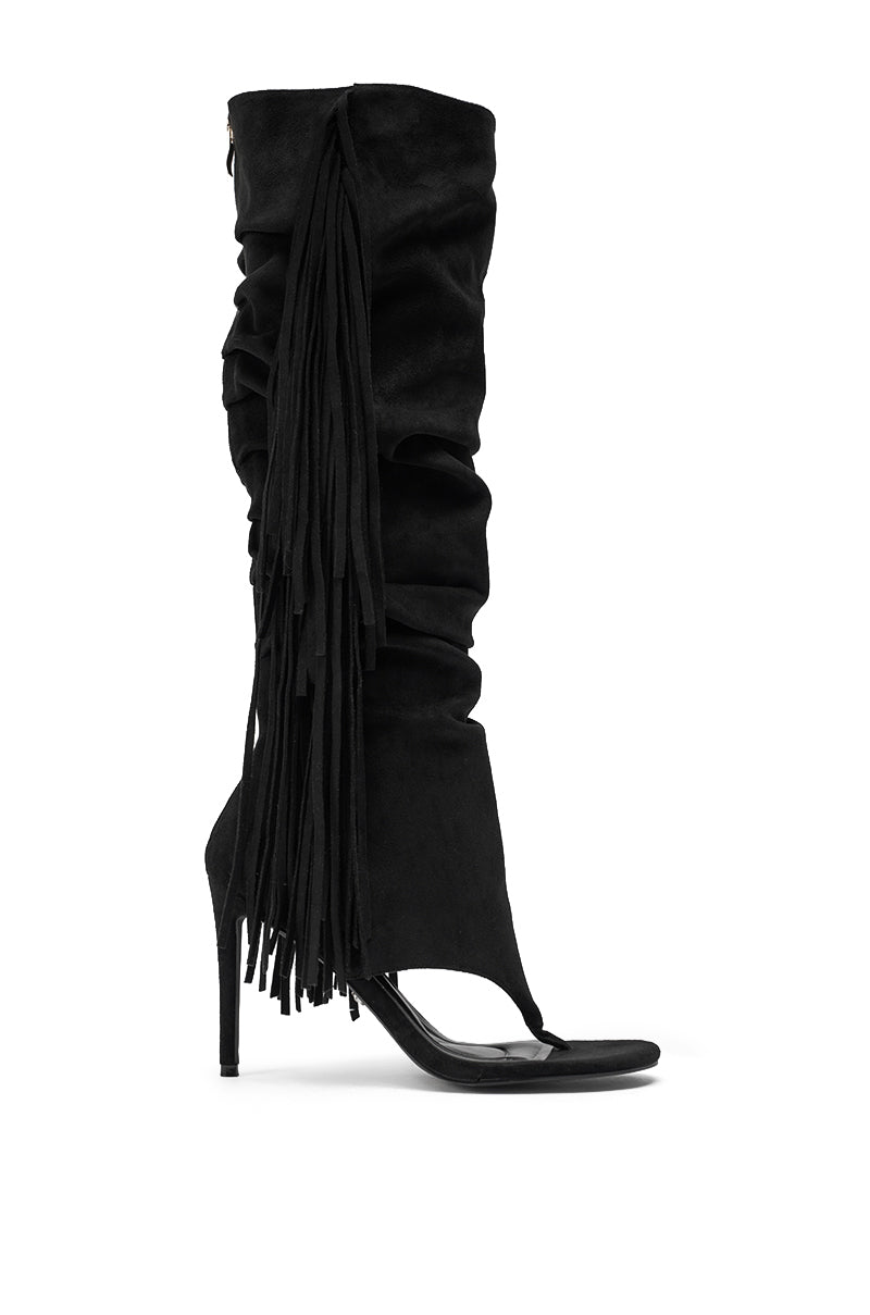 The AZALEA WANG JOHANNA BLACK FRINGE GLADIATOR SANDAL features a slouched knee-high shaft, side fringe detail, open toe, and sleek stiletto heel. 4