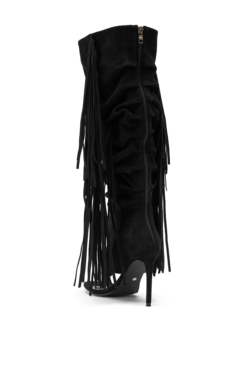 The AZALEA WANG JOHANNA BLACK FRINGE GLADIATOR SANDAL features a knee-high black design with a stylish open toe, stiletto heel, side zipper, ruffled suede material, and long fringe detailing along the sides. 6