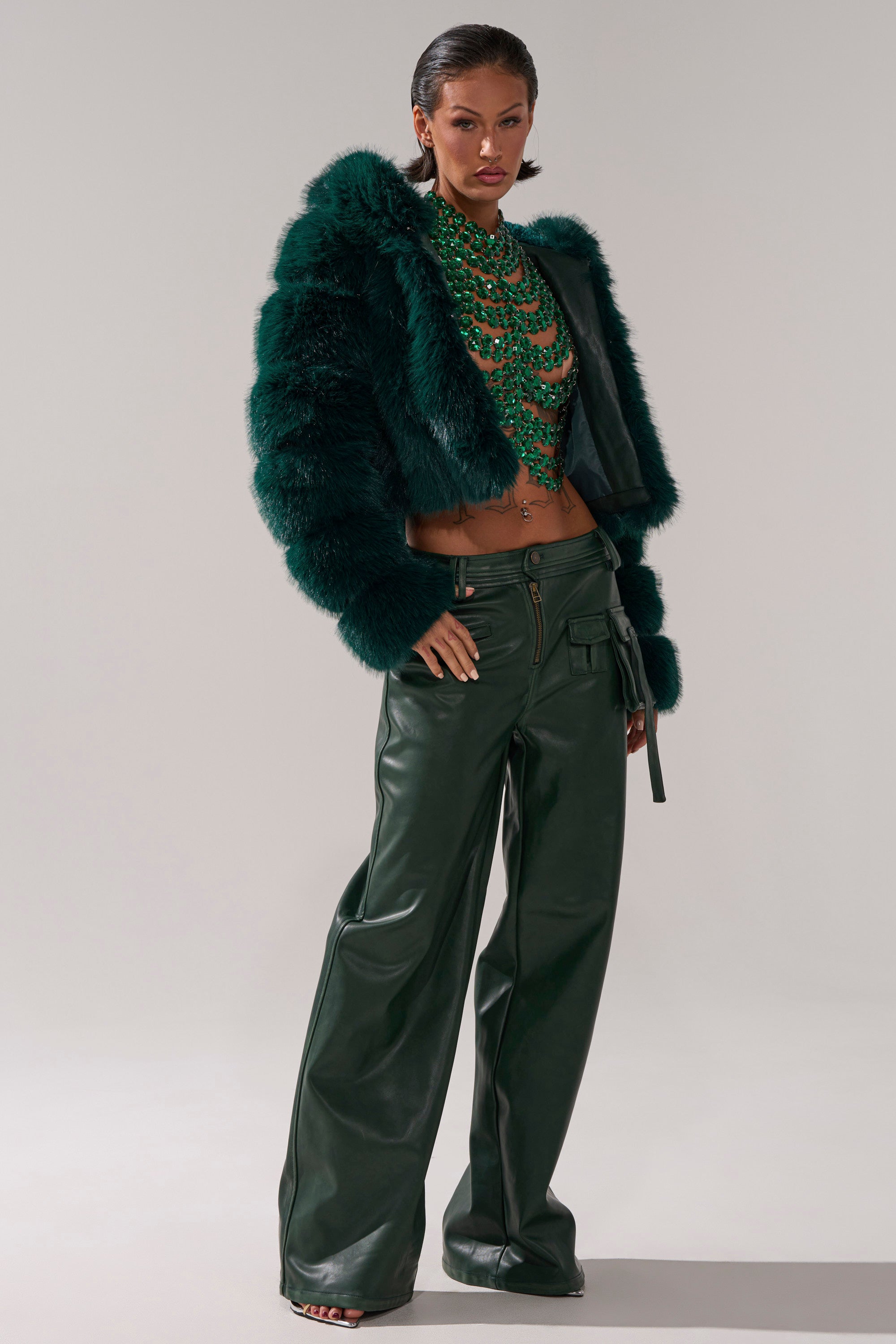 A woman wearing the JOLENE FAUX FUR COAT IN EMERALD GREEN and a green necklace from AKIRA. 7