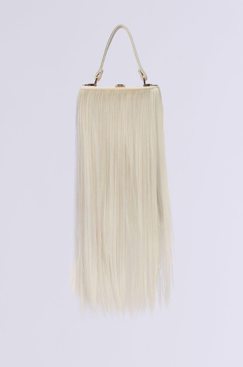 The JOSHIE SYNTHETIC HAIR TRUNK PURSE features a campy look with long, cream-colored fringes resembling synthetic hair. Its minimalist design and simple handle stand out elegantly against a plain white background.