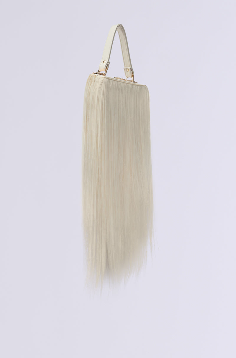The JOSHIE SYNTHETIC HAIR TRUNK PURSE features long, flowing platinum blonde synthetic hair that cascades elegantly. The light-colored handle stands out against a plain white background, highlighting its unique and striking design.