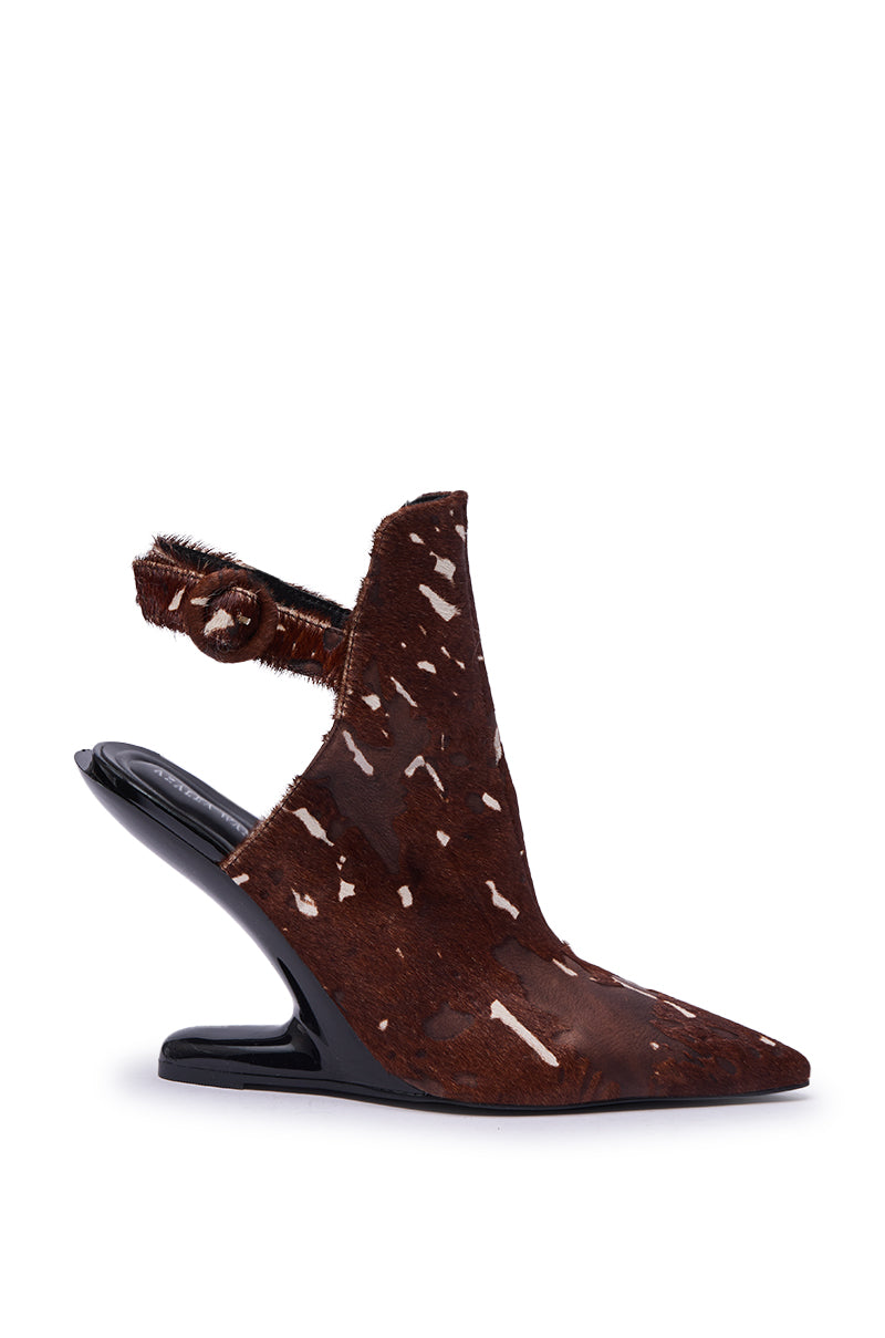 The AZALEA WANG JOST BROWN MULTI WEDGE PUMP features genuine brown and white calf hair in a cow print, a pointed toe, slingback strap, and a sculptural black wedge heel for a chic look.