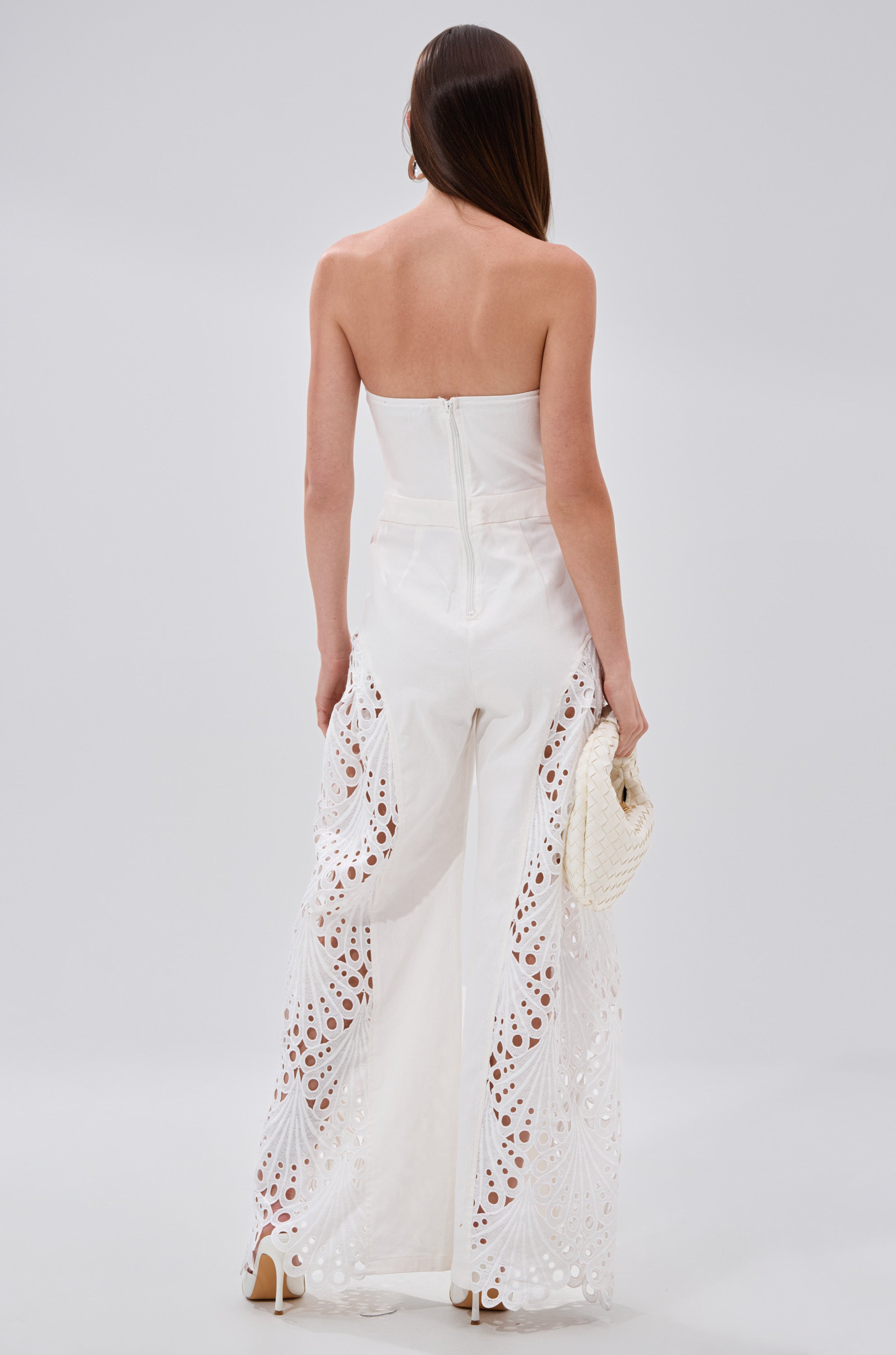 A woman exudes effortless elegance in the EASY BREEZY DENIM JUMPSUIT IN WHITE. 4
