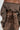 A person wears the "Broke My Heart" off-the-shoulder brown long-sleeve sweatshirt, paired with a high-waisted skirt featuring a corset-style lace-up back closure. The ensemble boasts a vintage, distressed appearance with its cropped silhouette.