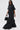 A woman in large black sunglasses walks, carrying a small black handbag and wearing the HAPPY HOUR FRENCH TERRY JUMPSUIT—an oversized, semi-stretchy knit cotton jumpsuit with short sleeves, large front pockets, and black shoes.