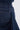 Close-up of the back of a person wearing the LUNA DENIM MAXI DRESS in dark blue denim with visible stitching. A long piece of denim fabric, resembling an A-line silhouette, is attached near the side pocket and drapes downward.