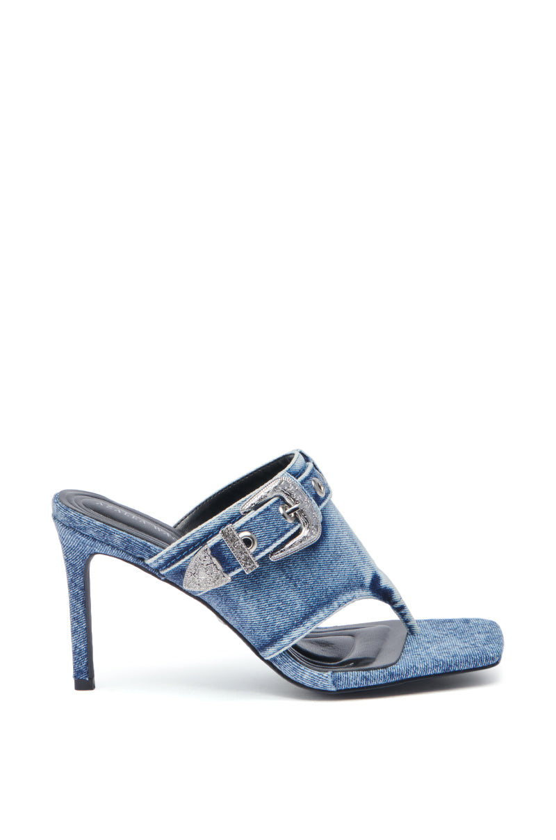 The AZALEA WANG JULIJA DENIM THONG STILETTO SANDAL features a denim upper, open square thong toe, thick strap with a bold silver buckle, and a slim stiletto heel covered in matching denim.